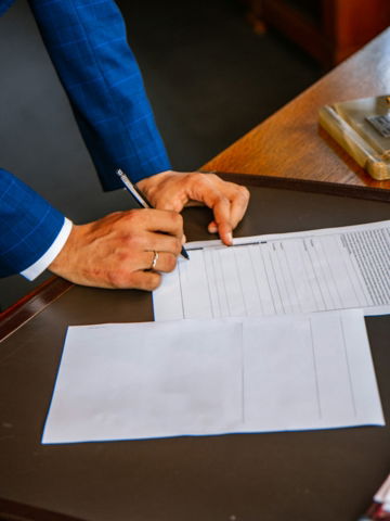 person writing on white form paper